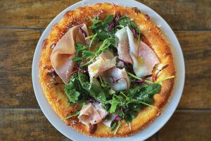 Prosciutto and pea greens pizza