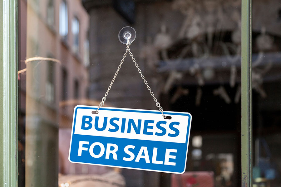 Image of a window with a sign that reads "Business for sale."