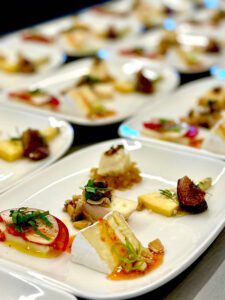 Image of cheeses paired with fruit, vegetables, nuts and herbs.
