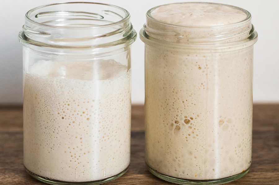 Image of two glass jars with sourdough starters at different hydration levels.