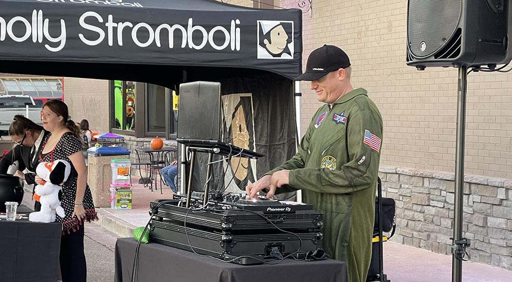 Image of DJ spinning tunes at the Wholly Stromboli community Halloween party.