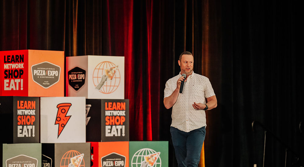 Image of Jeremy White addressing attendees at the keynote address during International Pizza Expo 2025.