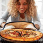 Image of a woman taking a pizza out of the oven.