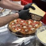 Image of a challenger grating cheese on their pizza during the International Pizza Challenge
