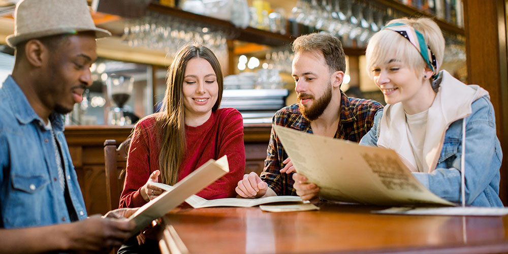 Image of restaurant customers reading menus.