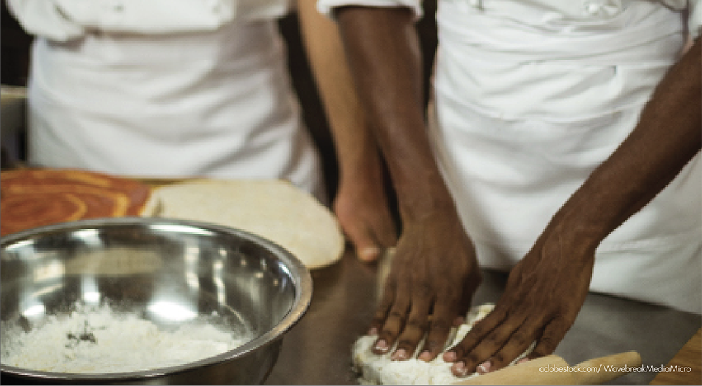 Image of two sets of hands working on dough.